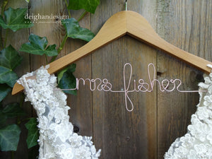 Light brown wooden hanger with custom base wire shaped into name