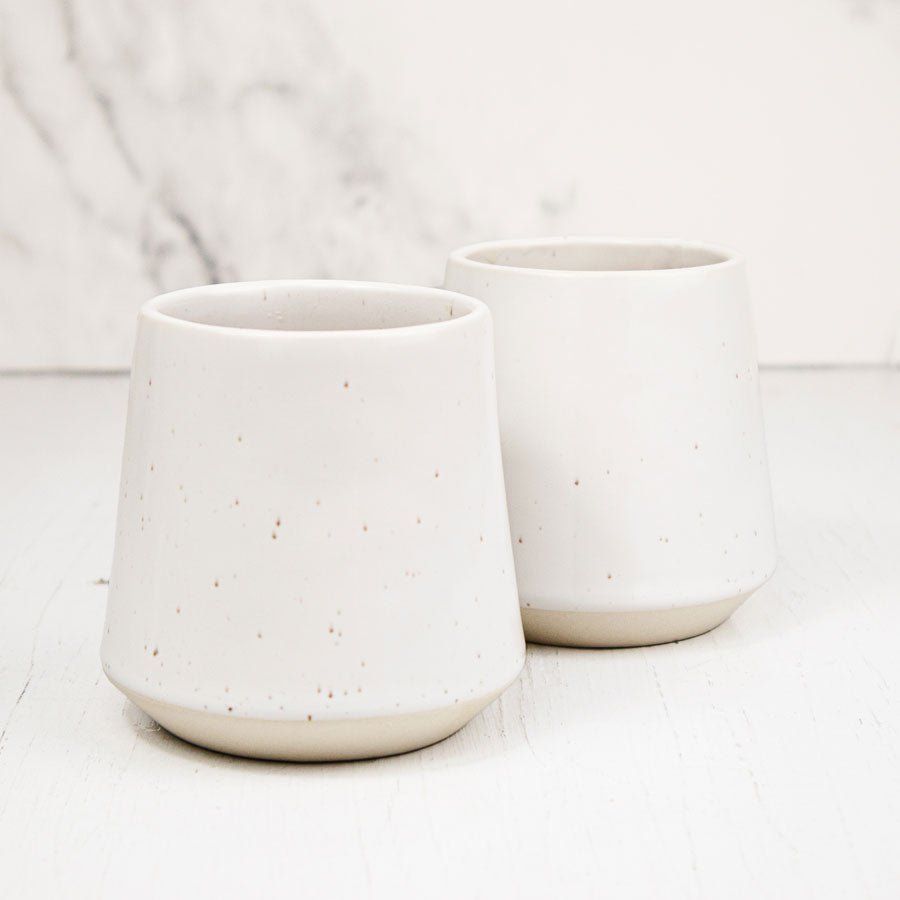 Stoneware mug with cool white glaze, subtle speckle effect and unglazed natural clay base.
