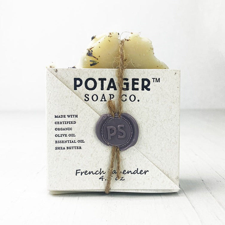 A light beige box, tied with twine, holds a bar of French Lavender soap.