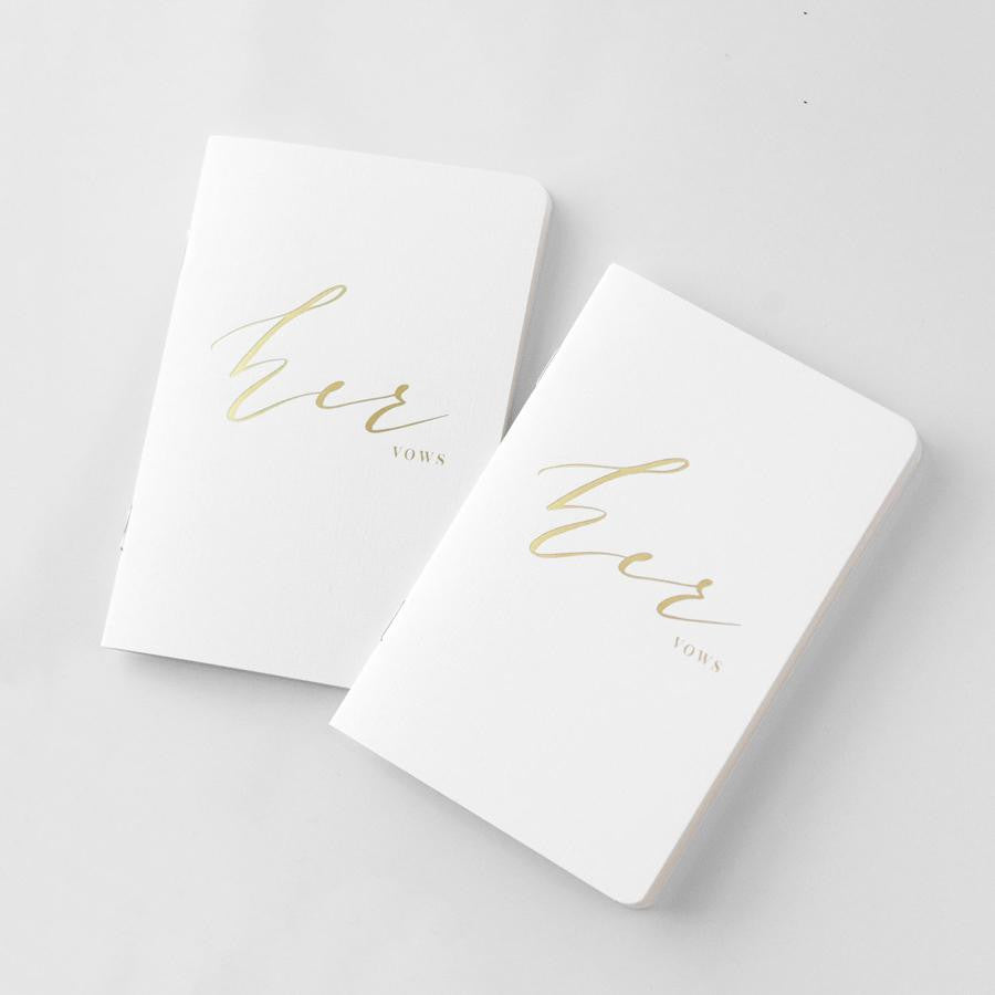 Her and her vow books, white linen cover, metallic gold foil stamping, rounded corners, saddle stitch binding featured on a white background.