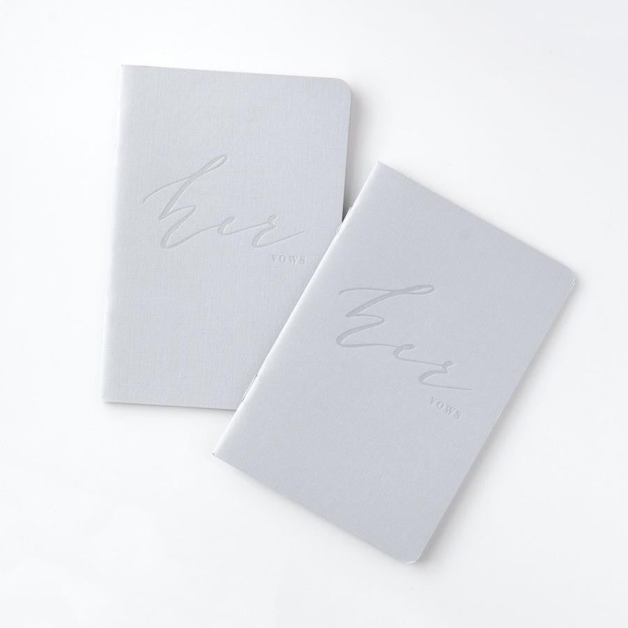 Her and her gray linen letterpressed vow books, featured in a white background