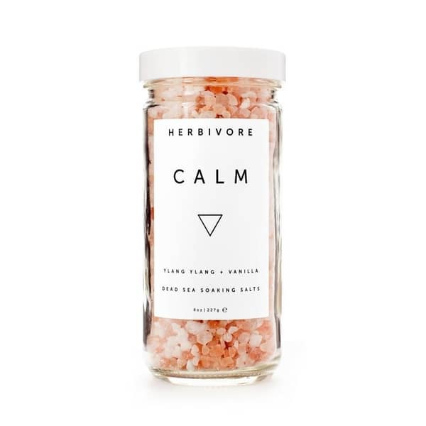 herbivore brand bath salts in calm scent pink salt in clear glass jar with white lid and a white label
