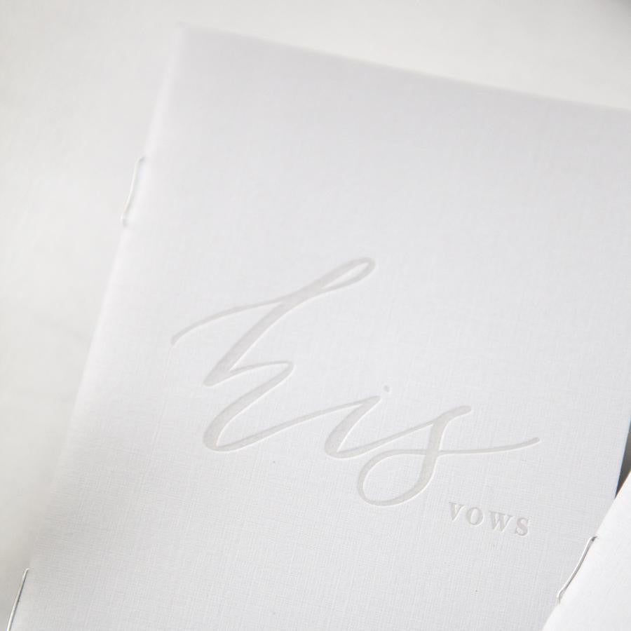 Close up of his vow book grey linen book with the letters his vows pressed.