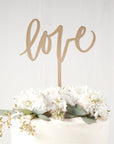 Love cake topper displayed in an image on top of a cake on a white background.