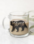 Mama bear mug featured: a transparent mug with a silhouette of a bear in black, cut out from it, on a marble-like background with an air plant next to it. 