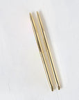 Two minimalist gold pens are featured on a white background.