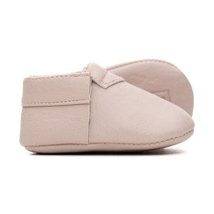 Side view of light pink colored baby moccasins