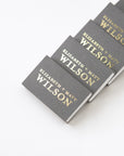 Five custom chroma slate matchboxes, personalized in brushed gold foil, with Elizabeth and Matt Wilson. 