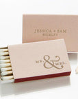 Custom macthboxes in pastel personalized in rose gold lettering wih Mr & Mrs, and Jessica + Sam Shirley onw is opened showing the white tip matches inside. 