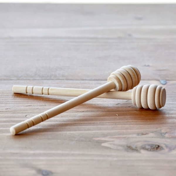 natural light wood honey drizzler sitting on wood table