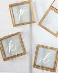 Personalized jewelry box, A gold-framed jewelery glass box rectangular shape, showing 4 in the image three closed witht the initials p,k, and l. One opened box in the corner.