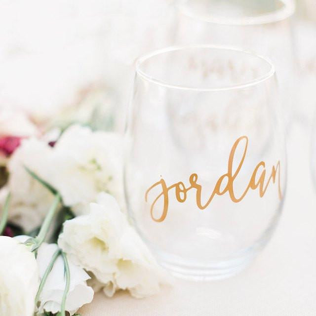 Stemless Wine Glass, shown in the image, is a transparent wine glass personalized with the name Jordan. Accompanied by white roses. 