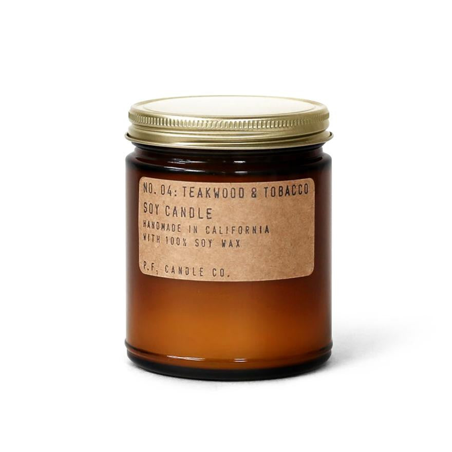 Teakwood & Tobacco Soy Candle, Candle shown in its brown container with gold lid and kraft brown paper label with black lettering. 
