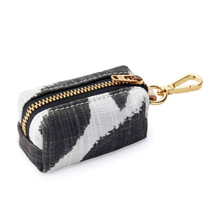 Side view of Black and white zebra design pouch with gold zipper and keychain hook