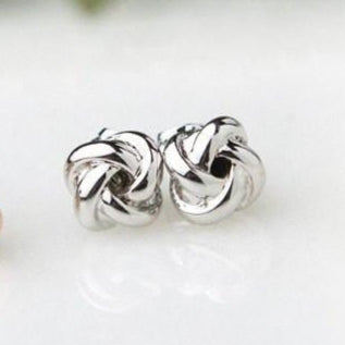 “Tie the Knot” white gold-plated earrings, featured on a marble-like background.