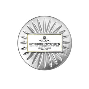 Top of silver candle jar starburst design and white label.