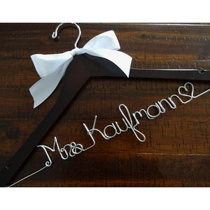 Dark wooden hanger with satin bow and silver hook. Personalized base wire shaped into name