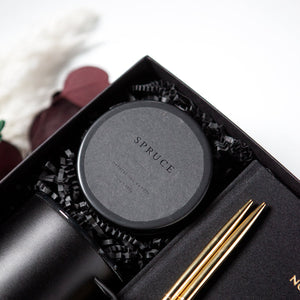 8 oz black candle tin with black label that reads "spruce"